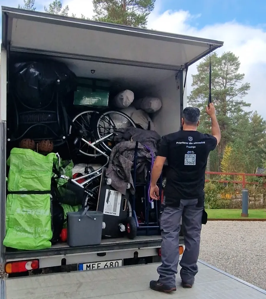 Fresh Flytts medarbetare vid en fullastad flyttbil